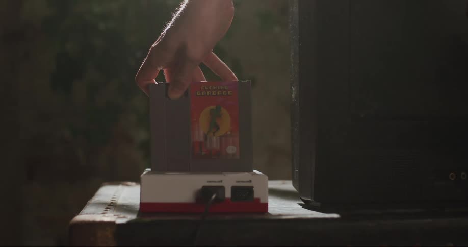 A male hand puts a video game disc in an older disc player