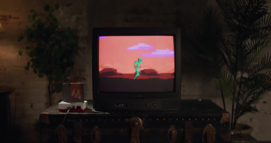 A video game plays on a box style television