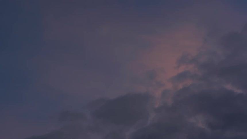 Sunlight reflects on the clouds in the sky as darker clouds move in front