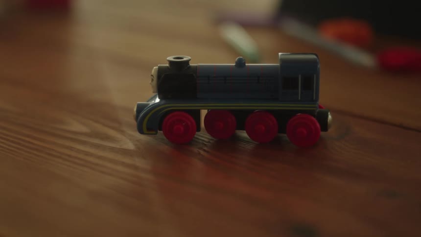 A close up of thomas the train toy on a wooden surface