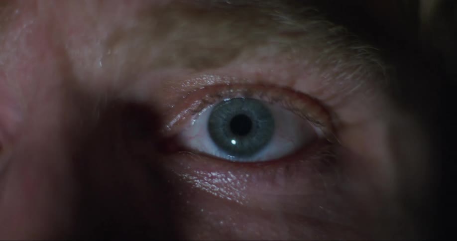 An extreme close up of a persons eyeball staring straight ahead and barely blinking