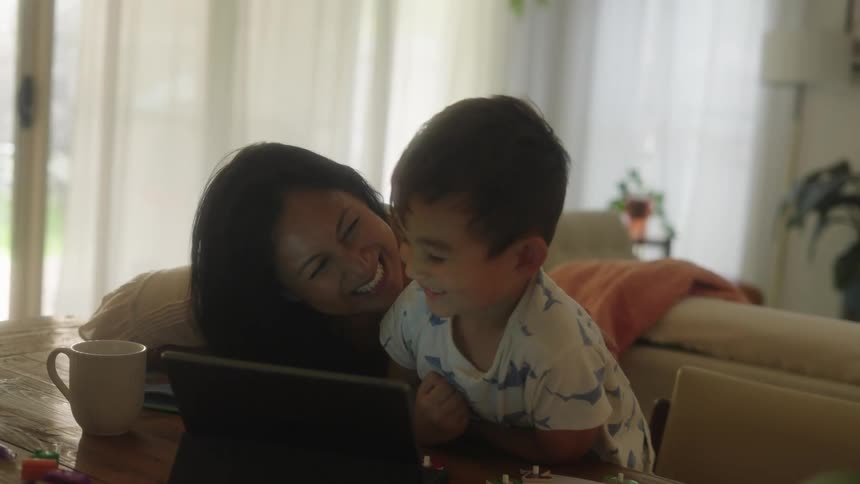 A mother and son watch something on a tablet