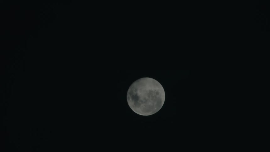 Full moon rises in the sky at night