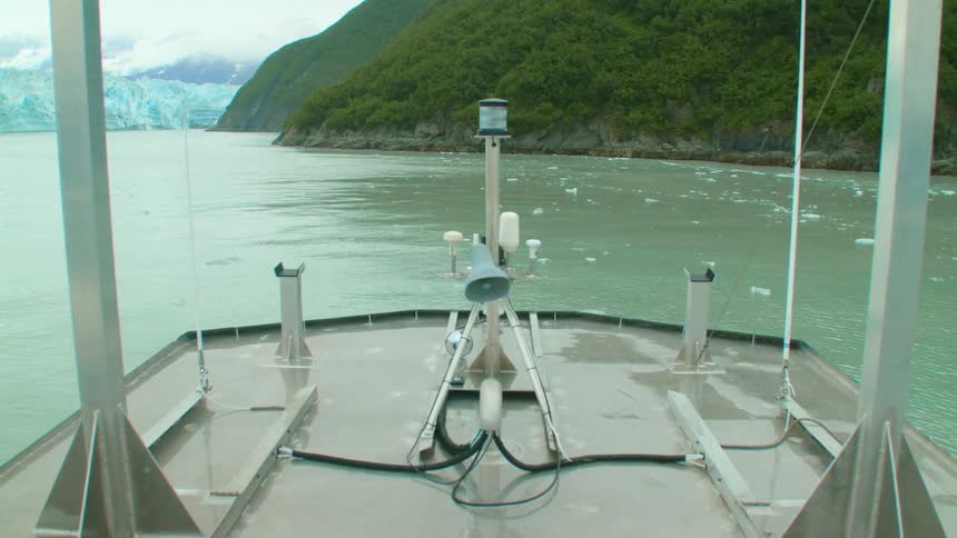 A boat sails toward islands in the ocean