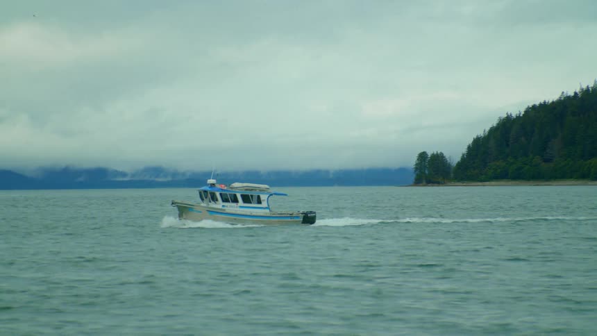 Boat travels on water on a cloudy day