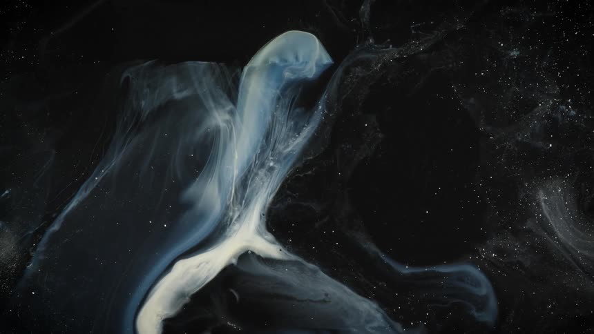 A blue and white substance is bent across the darkness as translucent areas move like a nebula in a star filled universe