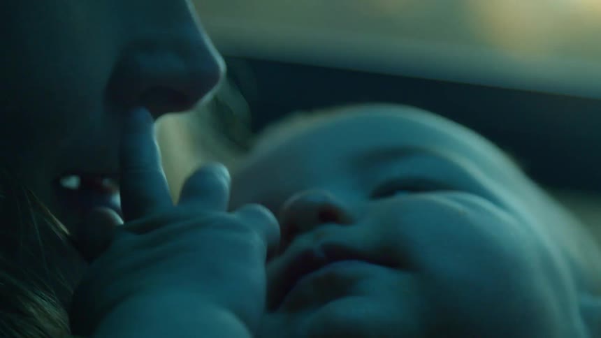 A mother is holding her baby in the car