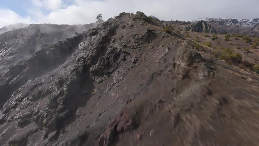 High speed FPV drone shot of dry, rugged mountains within a rocky landscape
