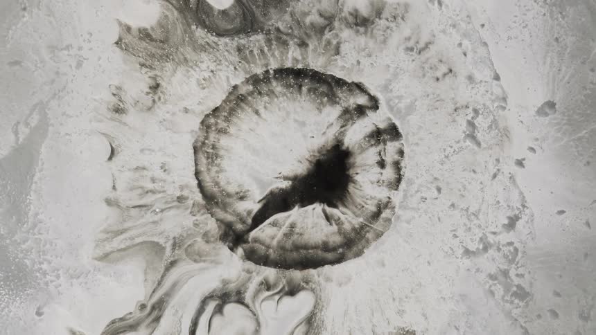 Abstract slomo movement of black and white paints expanding and looking like some kind of cosmic thing