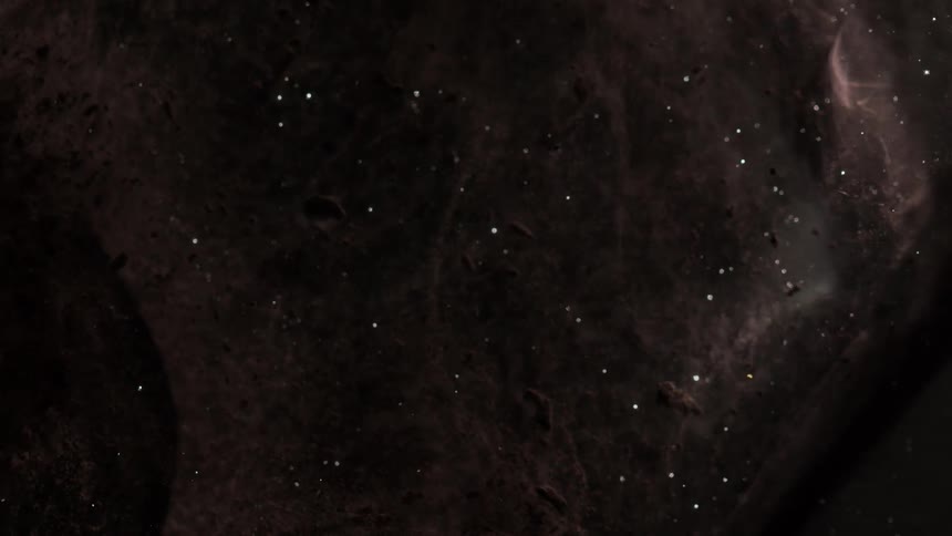 Brown mass flows through clear fluid dotted with white dots