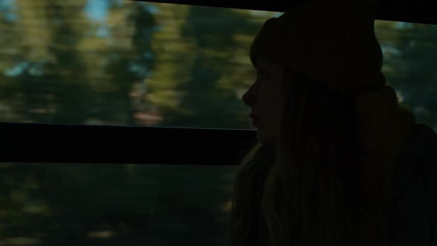 Blonde woman with wooly hair travels by bus looking out the window