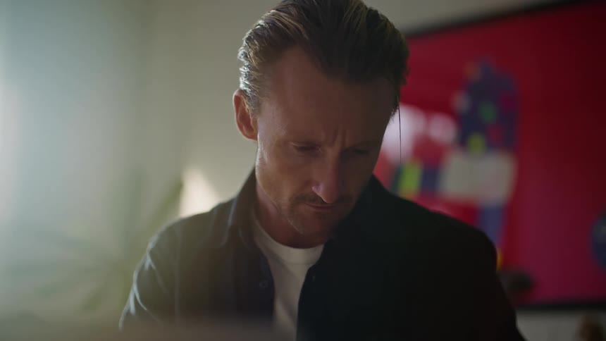 Businessman in black and white shirt writes down in notebook an idea occurring to him at the office