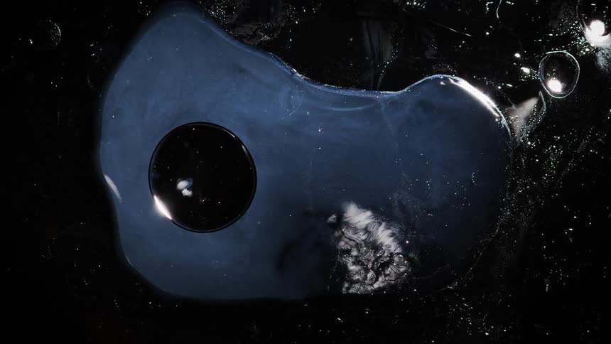 Abstract close up of black and silver liquid and oil bubbles and shimmer with reflection