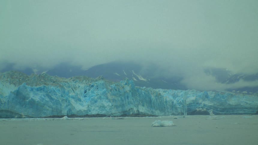 Glaciers sit atop a frozen ocean near a mountain range