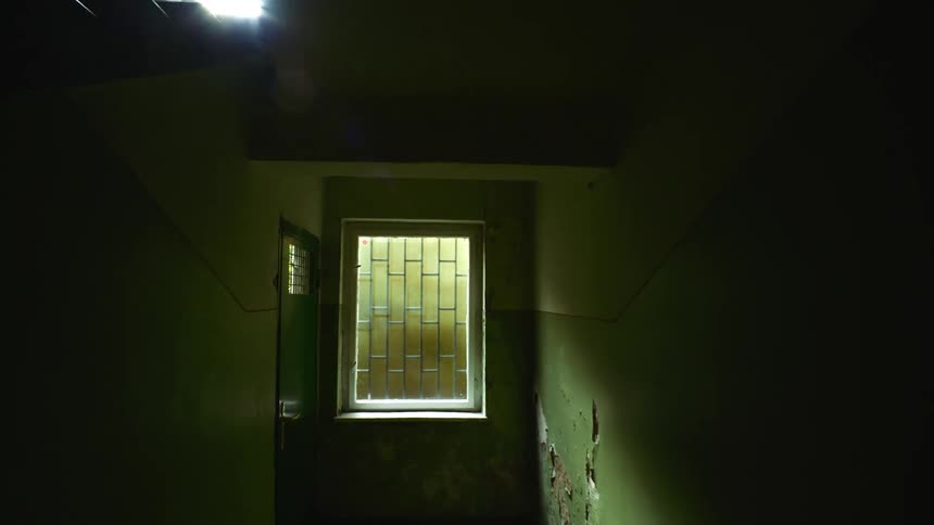 Torn wallpaper hangs on green wall of corridor at base of staircase
