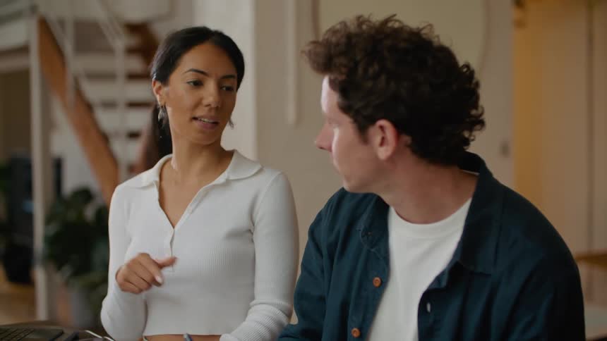 Colleagues discuss printed photos and take notes on a laptop