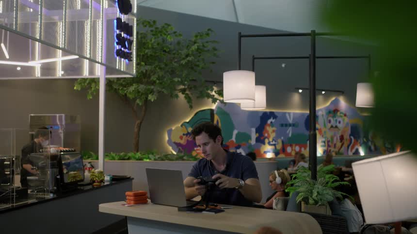 A man is indoors and is on his laptop in the day time