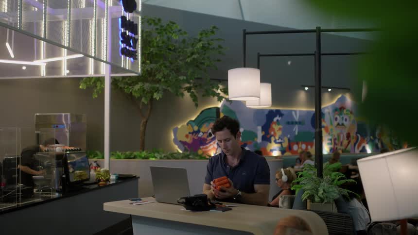 A man sits at his laptop in the cafe