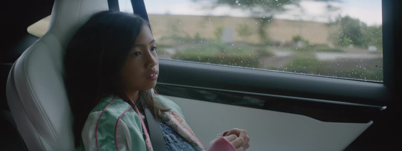 A child is riding in back of the car
