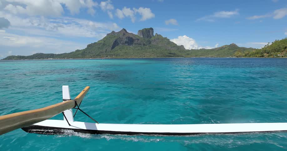 A boat glides across bright blue water