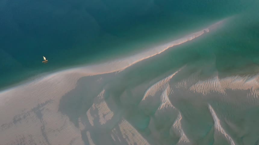 A view of the ocean around the day time and you can see a sail boat