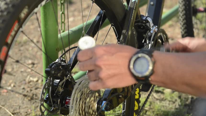 A person is oiling the chain on their bicycle