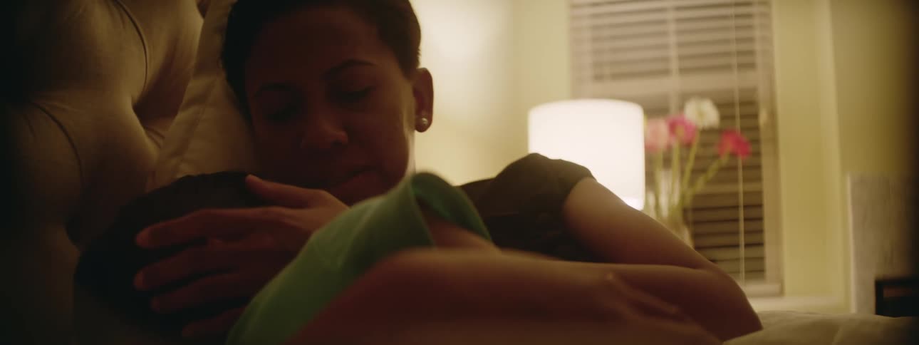 A mother cradles her child in bed