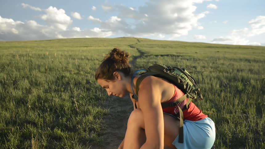 A young woman is running down the forest area in the day time
