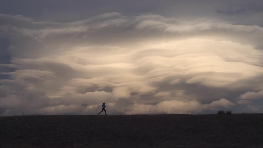 A young woman is jogging outdoors in the middle of the day