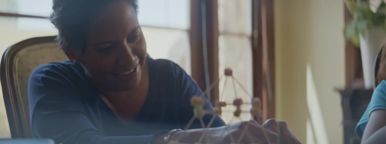 A mother and daughter are building with toothpicks