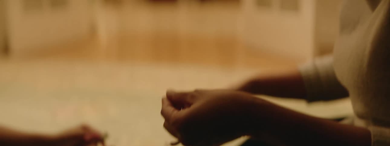 Adult woman sits on the floor making handmade bracelets at home