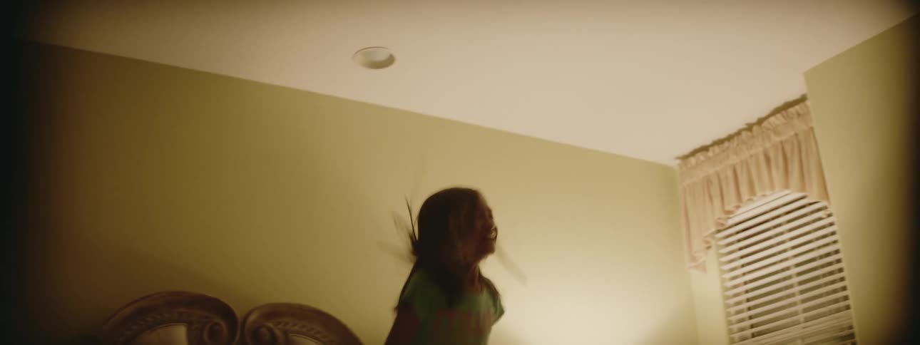 Girl jumps on bed in bedroom