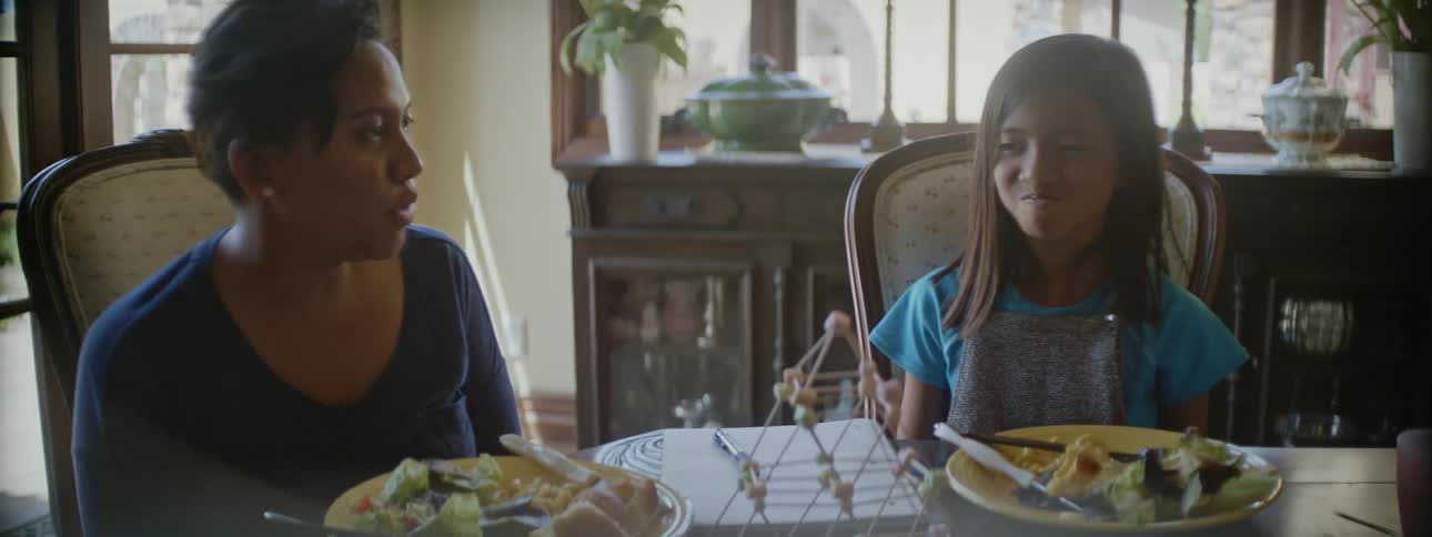 Mother and daughter assemble a model over the dining table at home