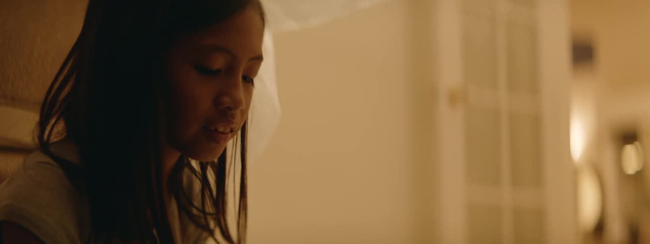 A young kid is sitting on a bed inside of her bedroom