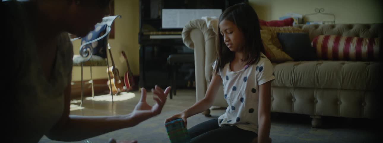 A mother and daughter play with toys in the living room