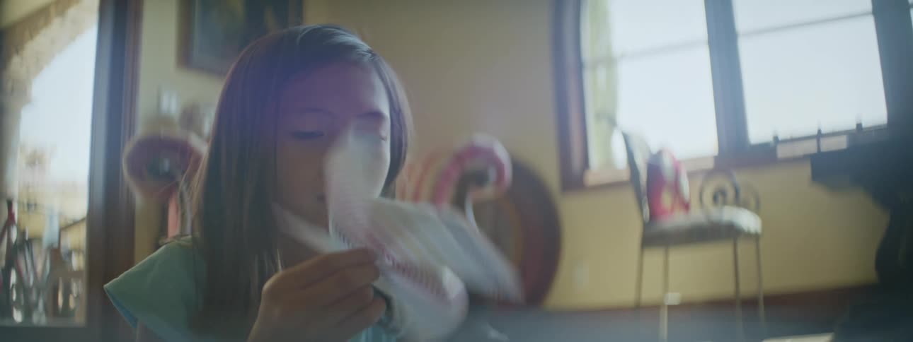 A young child is playing around inside of her home in the day time
