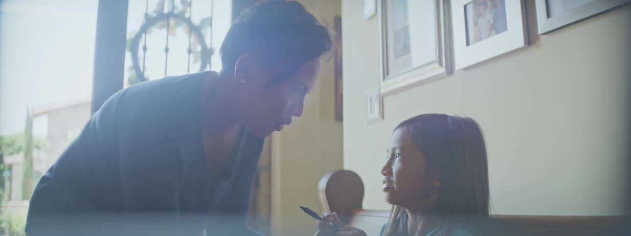 A mother leans down talking to her daughter