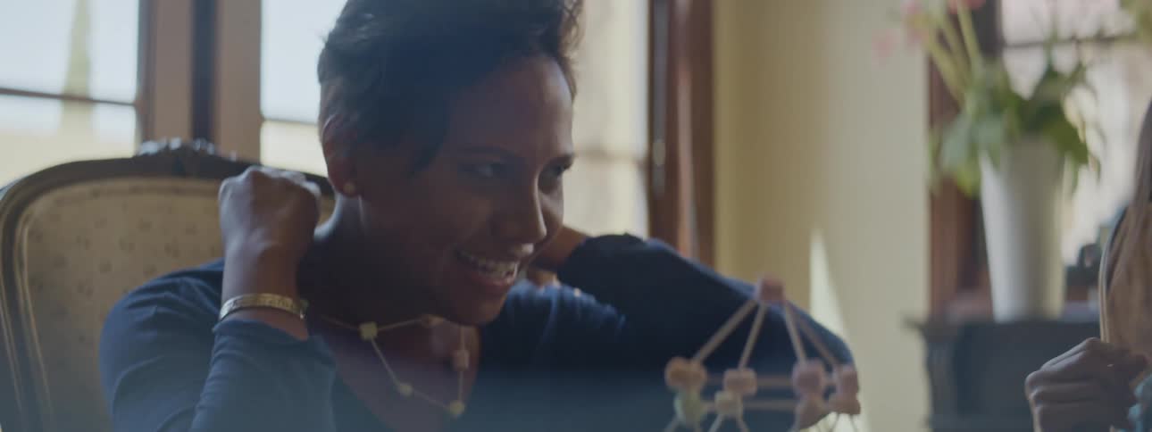 Mother and daughter have fun assembling and trying a homemade necklace