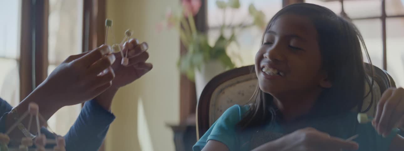 Mother and daughter laugh and have fun while making handcrafts together at home
