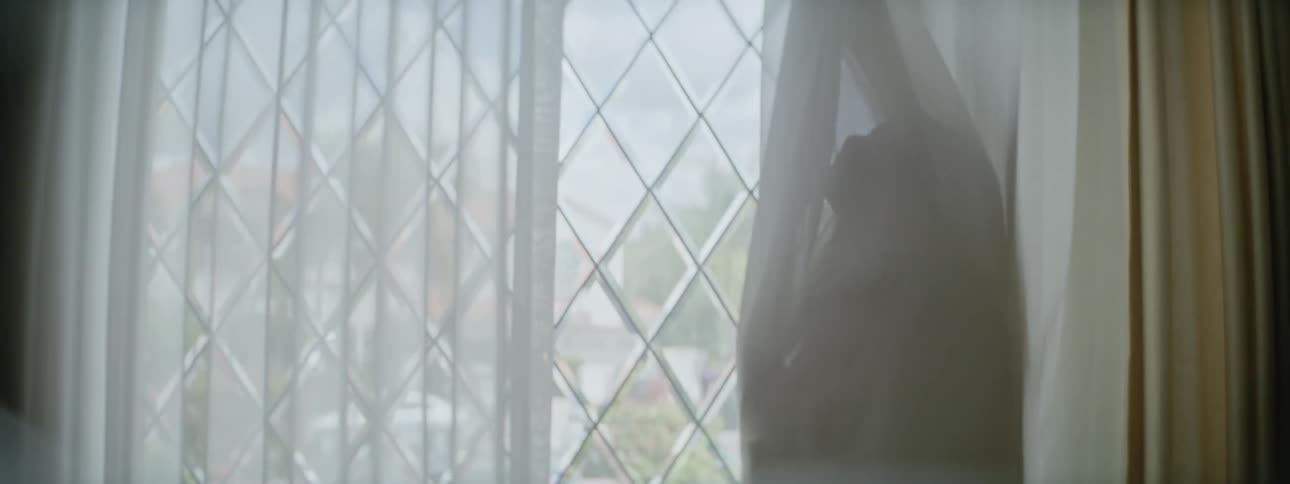 The view is of a kid inside of her home in the day time