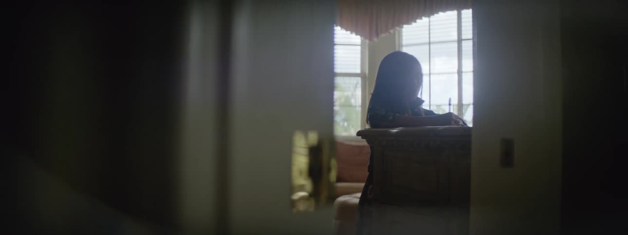 Young girl at home standing at a desk and writing on a piece of paper probably doing homework