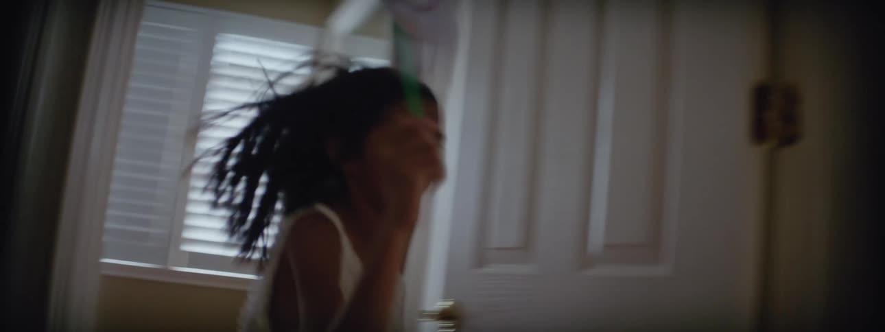 Happy girl carrying a paper windmill runs from room to room at home