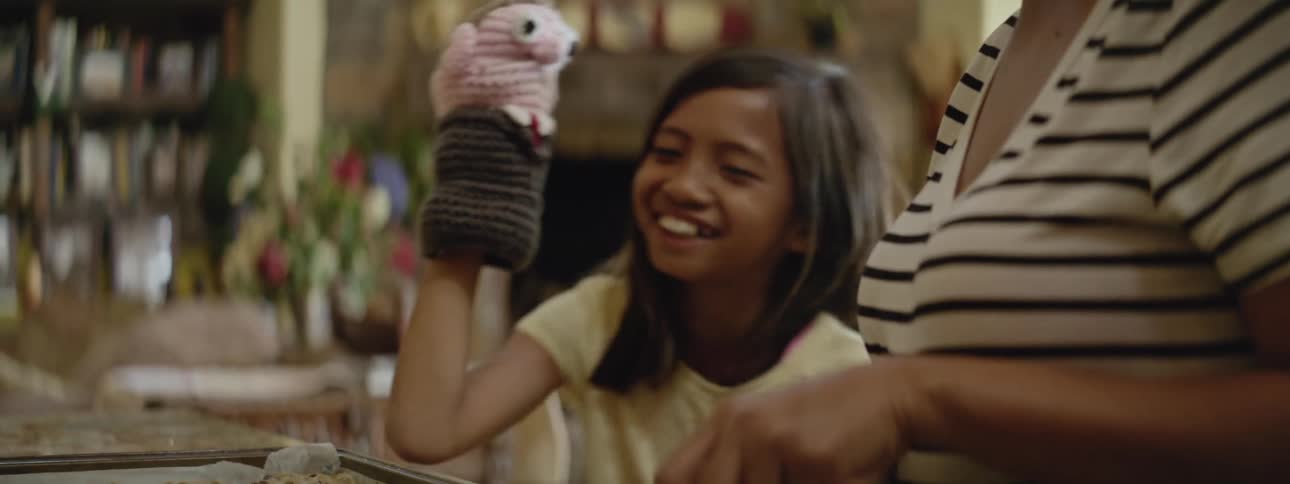 A child plays with her hand puppet