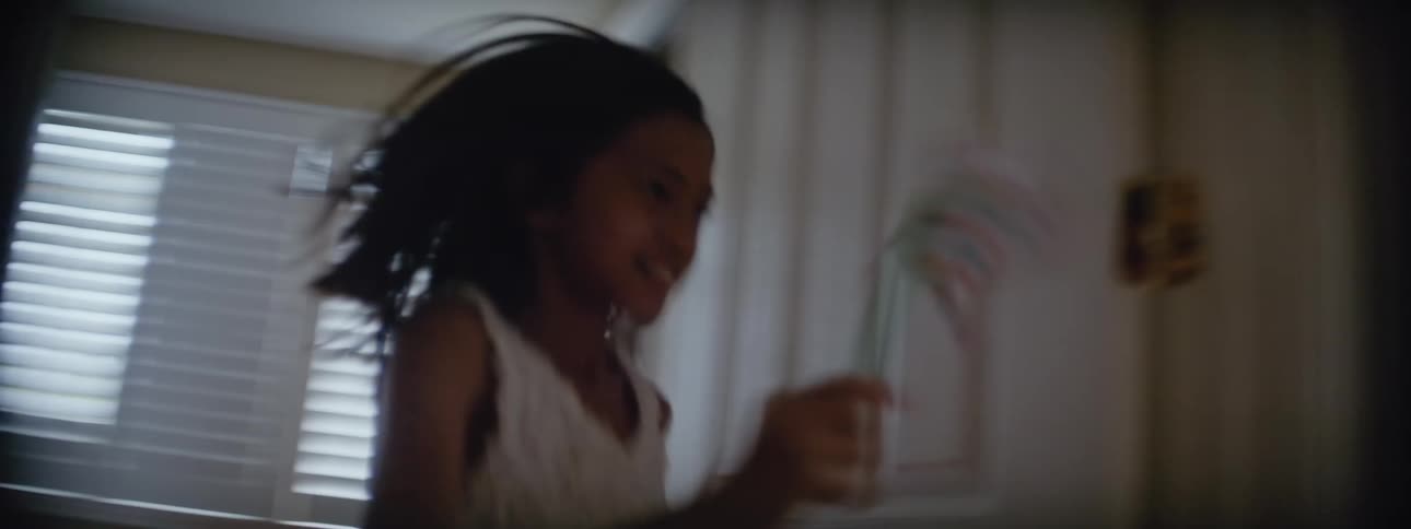 Young girl running through house with a pinwheel that she made