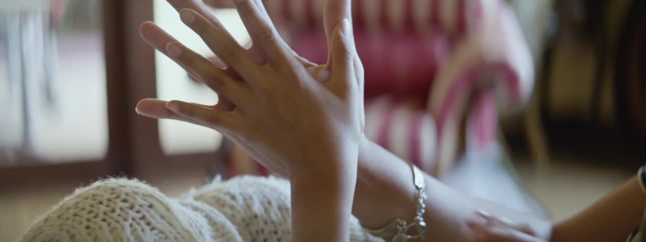 Close up of a mother and her daughter measuring the size of their hands