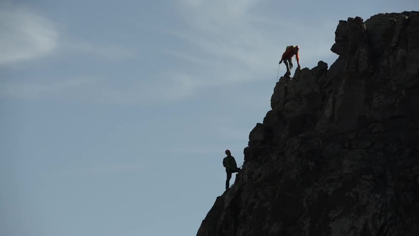 Two people are climbing the mountain