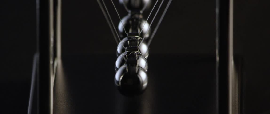 Small metal balls swing back and forth on executive toy
