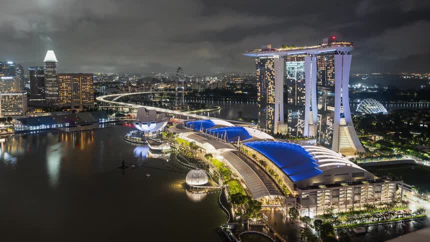 The modern city of Singapore along the coast is bustling at night