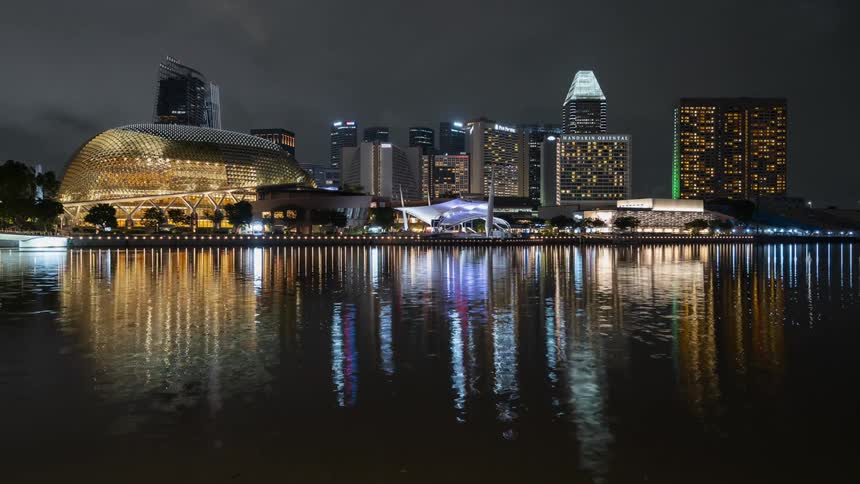 A time lapse of a waterway with a reflection of the Singapore city buildings at night