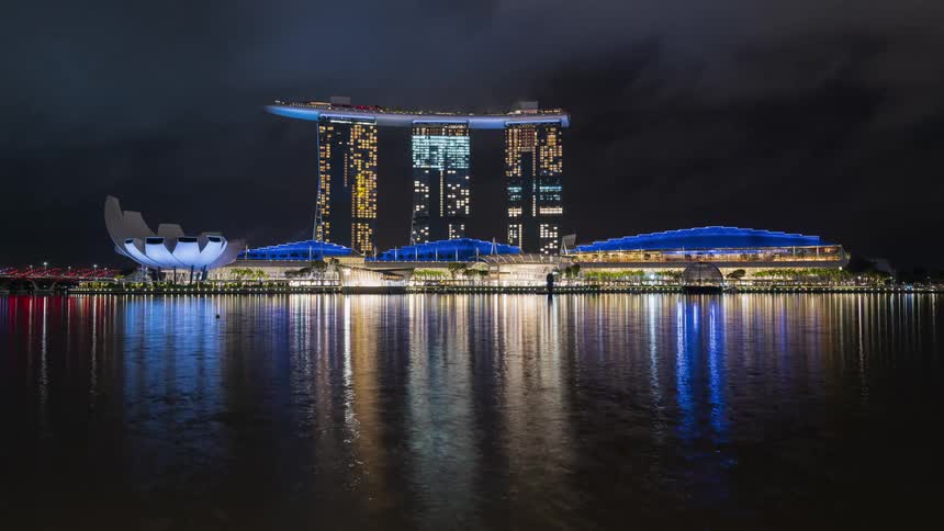 Coastal skyscrapers reflect off the sea below in Singapore Bay